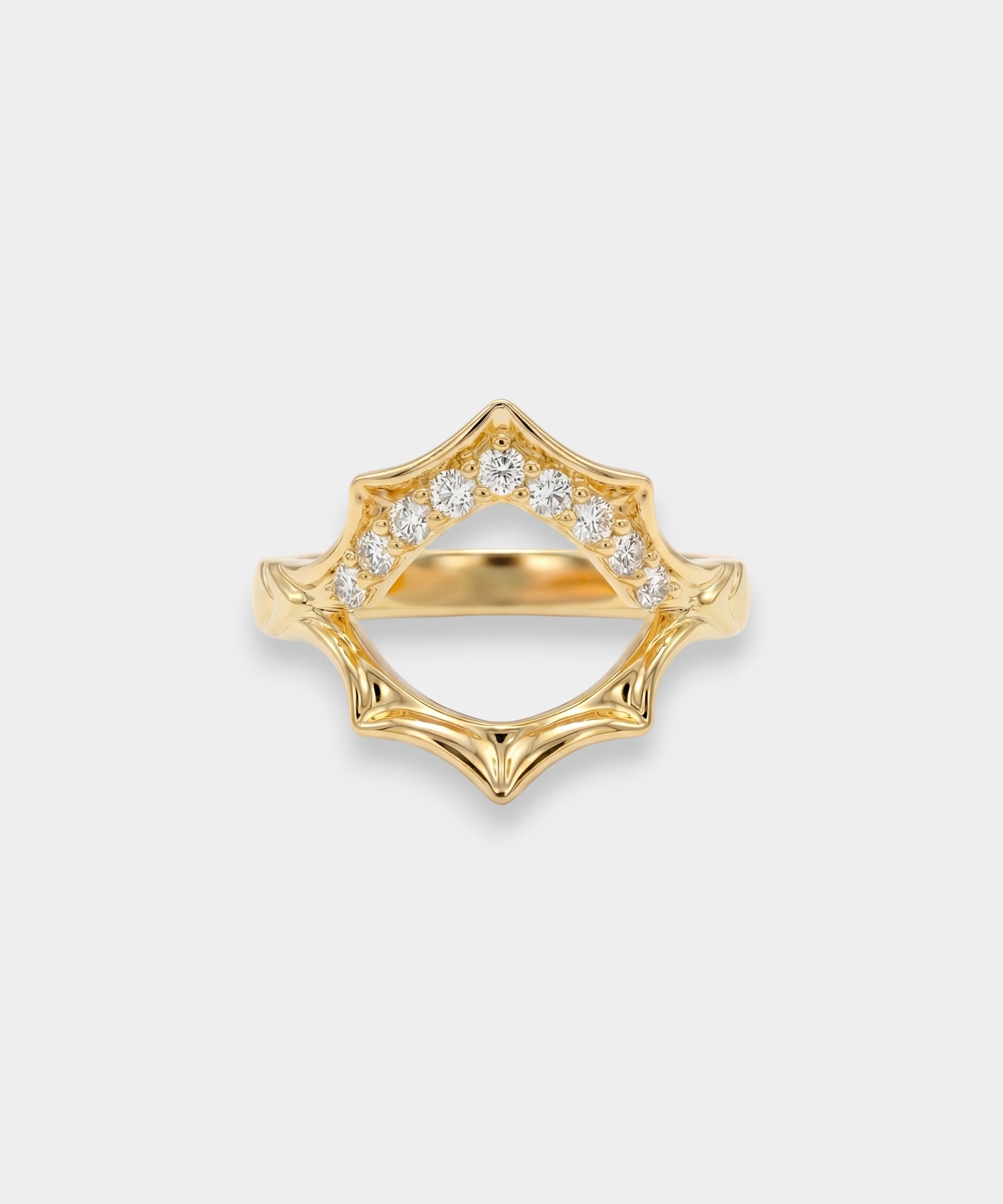 Gold ring with diamond accents on a light gray background