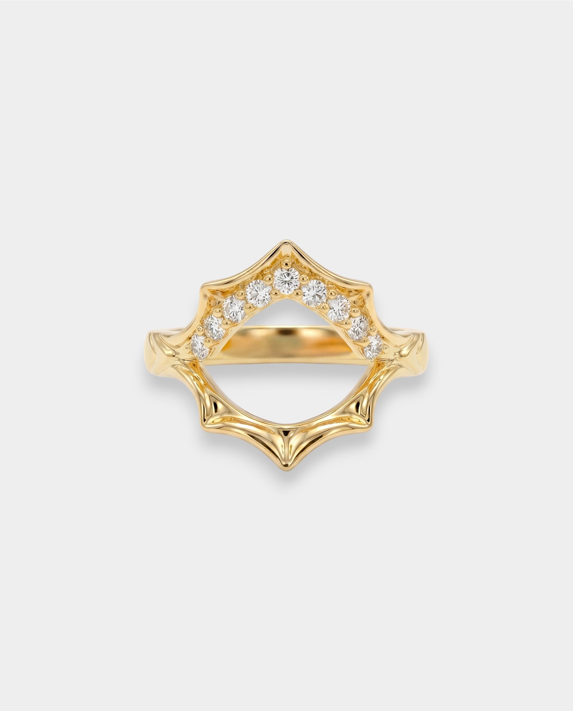 Gold ring with diamond accents on a light gray background
