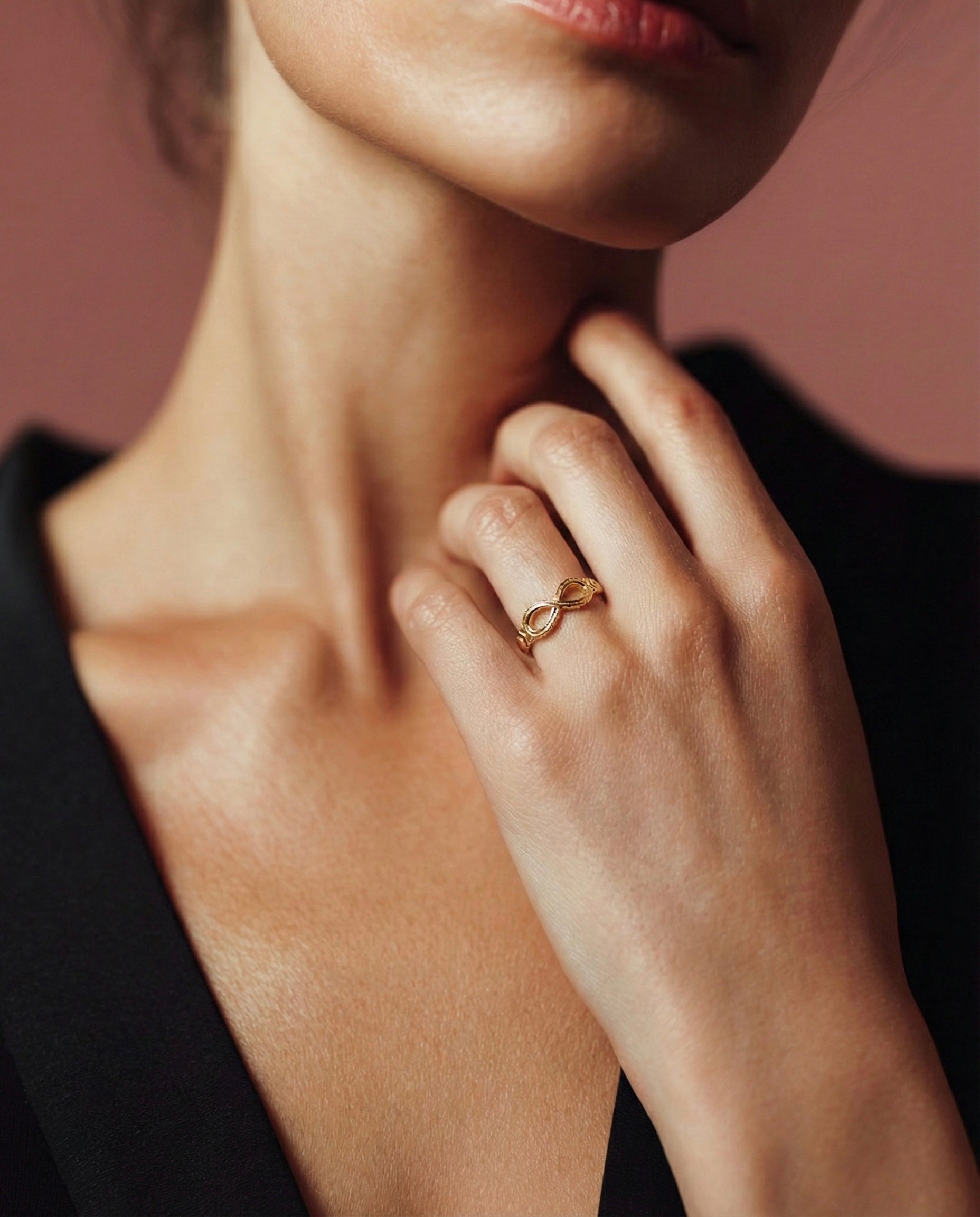 Close-up of a hand wearing a gold ring on a blurred background