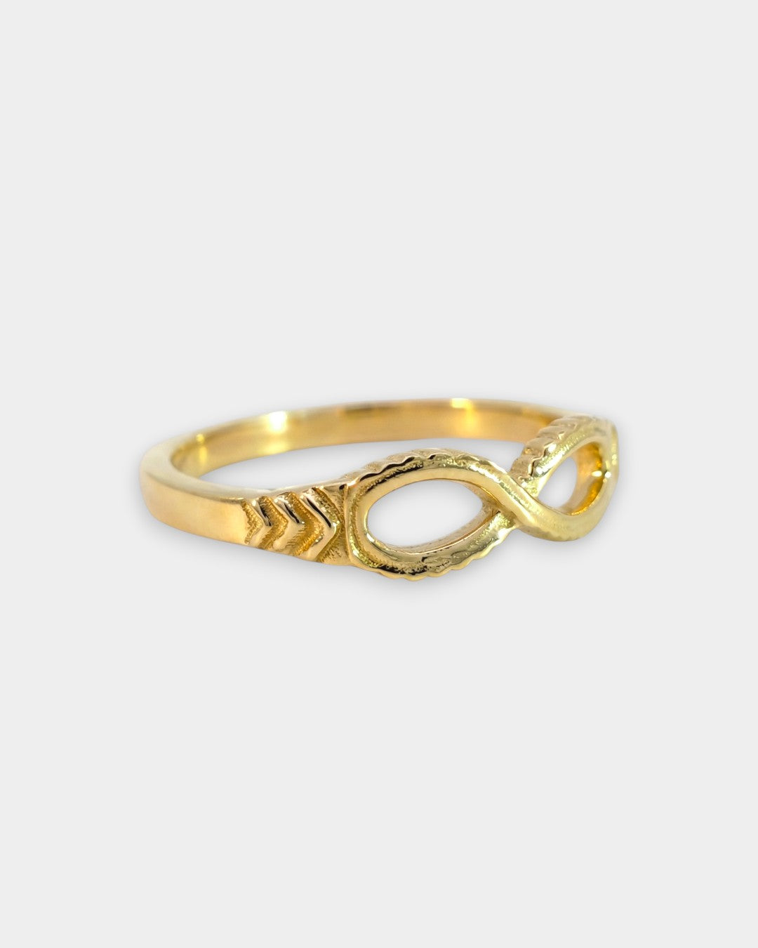 Gold infinity ring on a white background