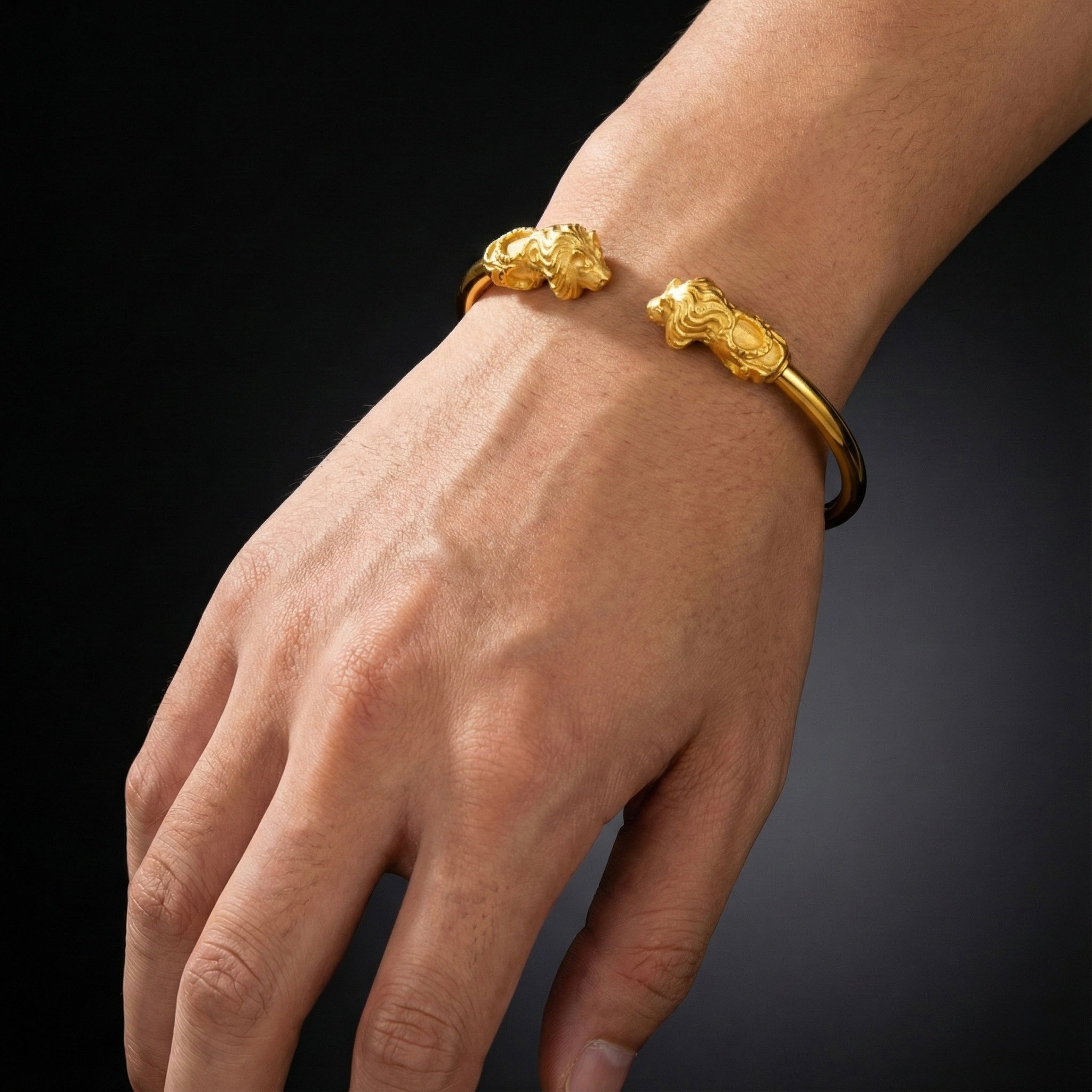Gold bracelet on a wrist against a dark background