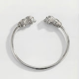 Silver bracelet with lion head designs on a white background
