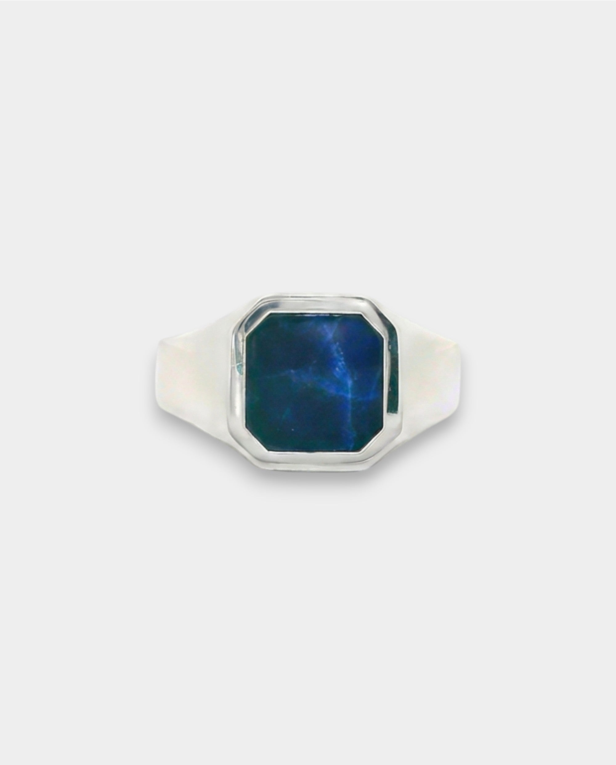 Silver ring with a blue stone on a white background