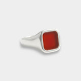 Silver ring with a red stone on a white background