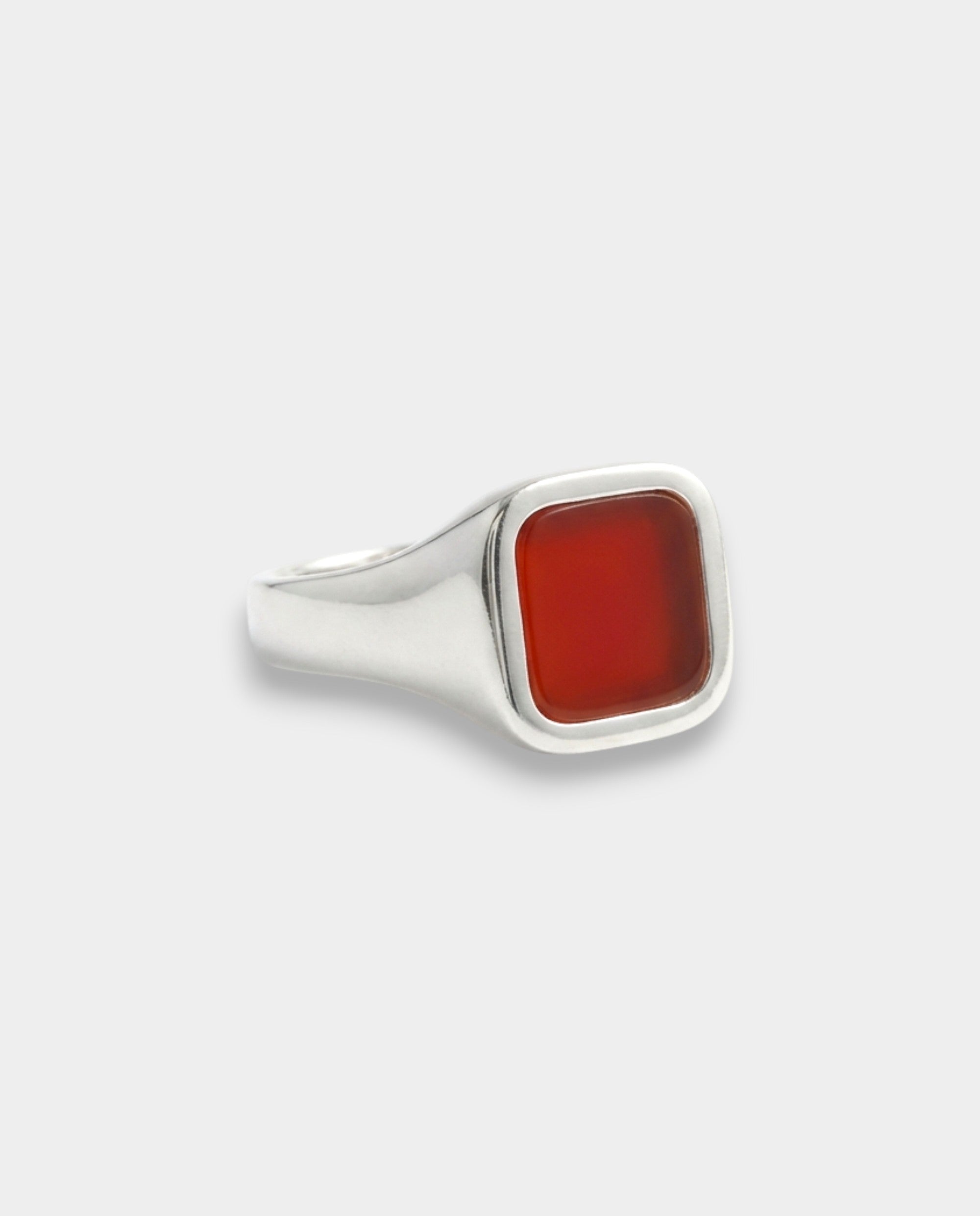 Silver ring with a red stone on a white background
