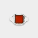 Silver ring with a rectangular red stone on a white background