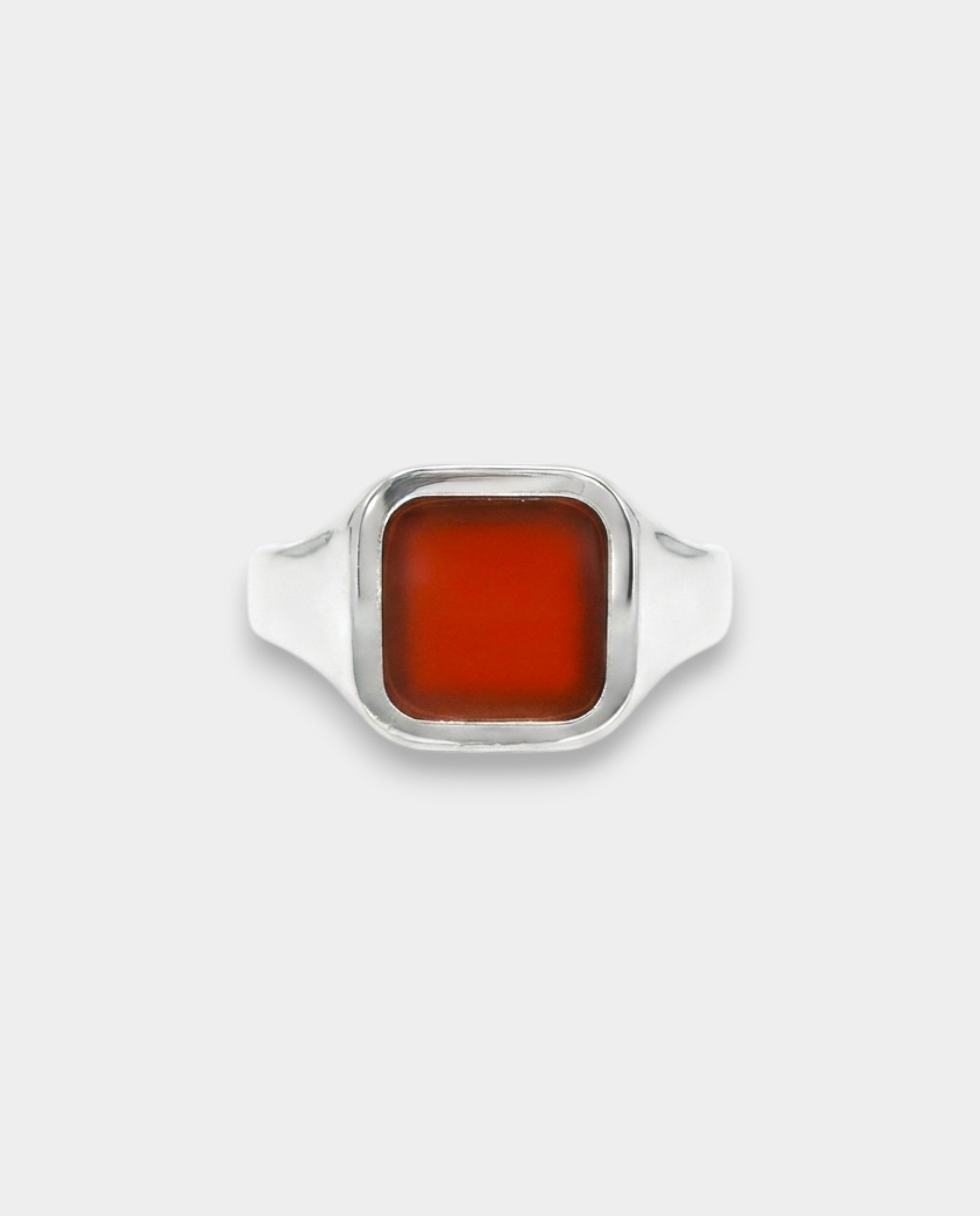 Silver ring with a rectangular red stone on a white background