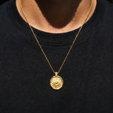 Gold coin necklace with sun image on a black shirt