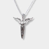 A silver pendant necklace featuring a dagger with wings, suspended from a delicate silver chain against a light gray background.
