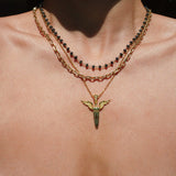 Necklace with a unique winged sword pendant on a person's neck
