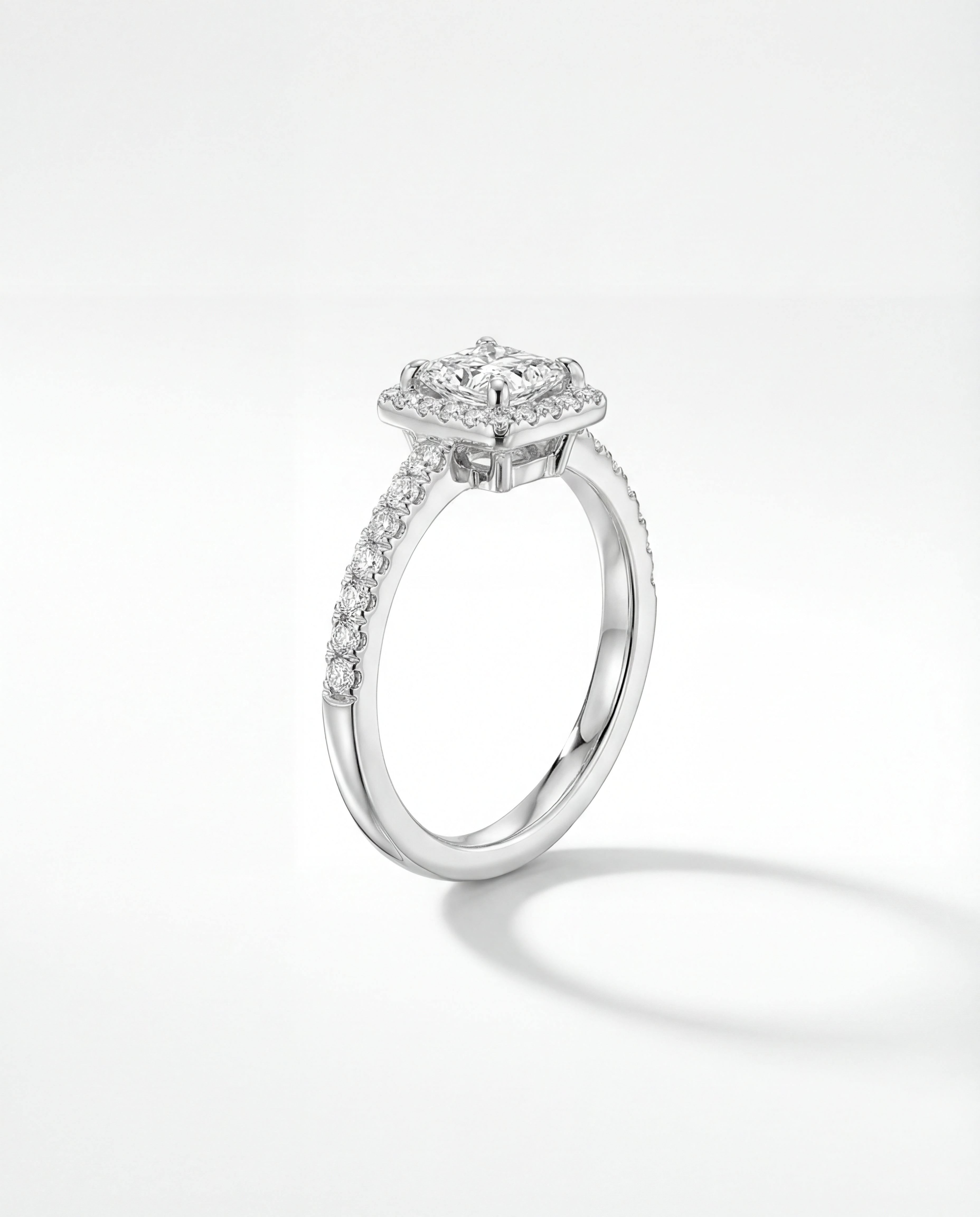 Engagement ring with a princess-cut diamond on a white background