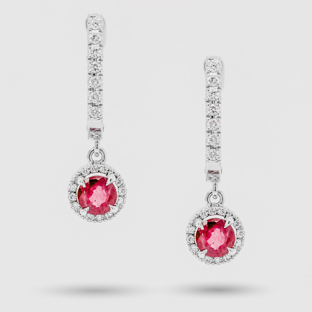 Pair of earrings with rubies and diamond accents on a light gray background