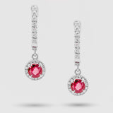 Pair of earrings with rubies and diamond accents on a light gray background