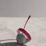 a ruby eternity ring on a cherry 