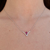 Necklace with a ruby gemstone worn by a person
