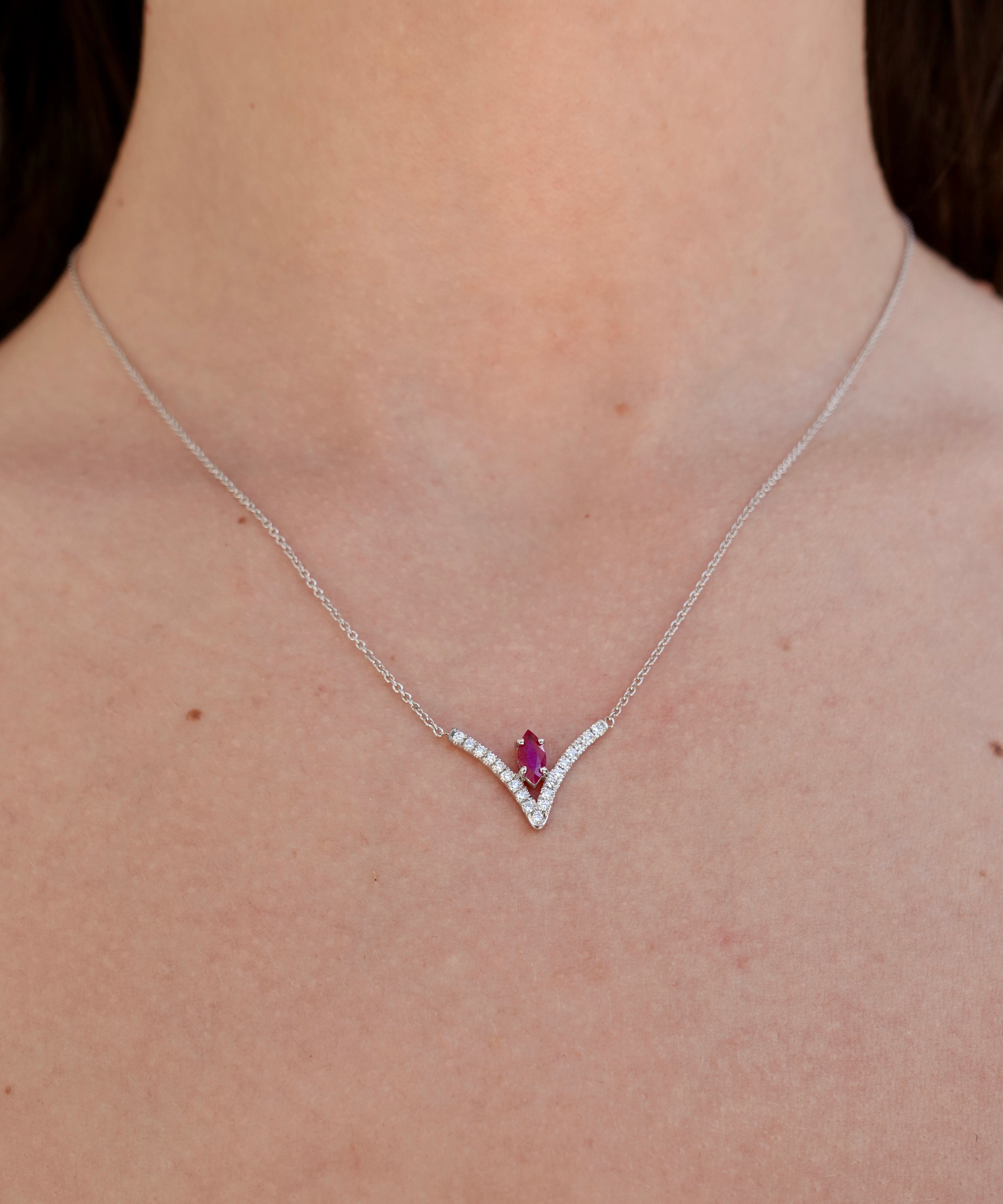 Necklace with a ruby gemstone worn by a person