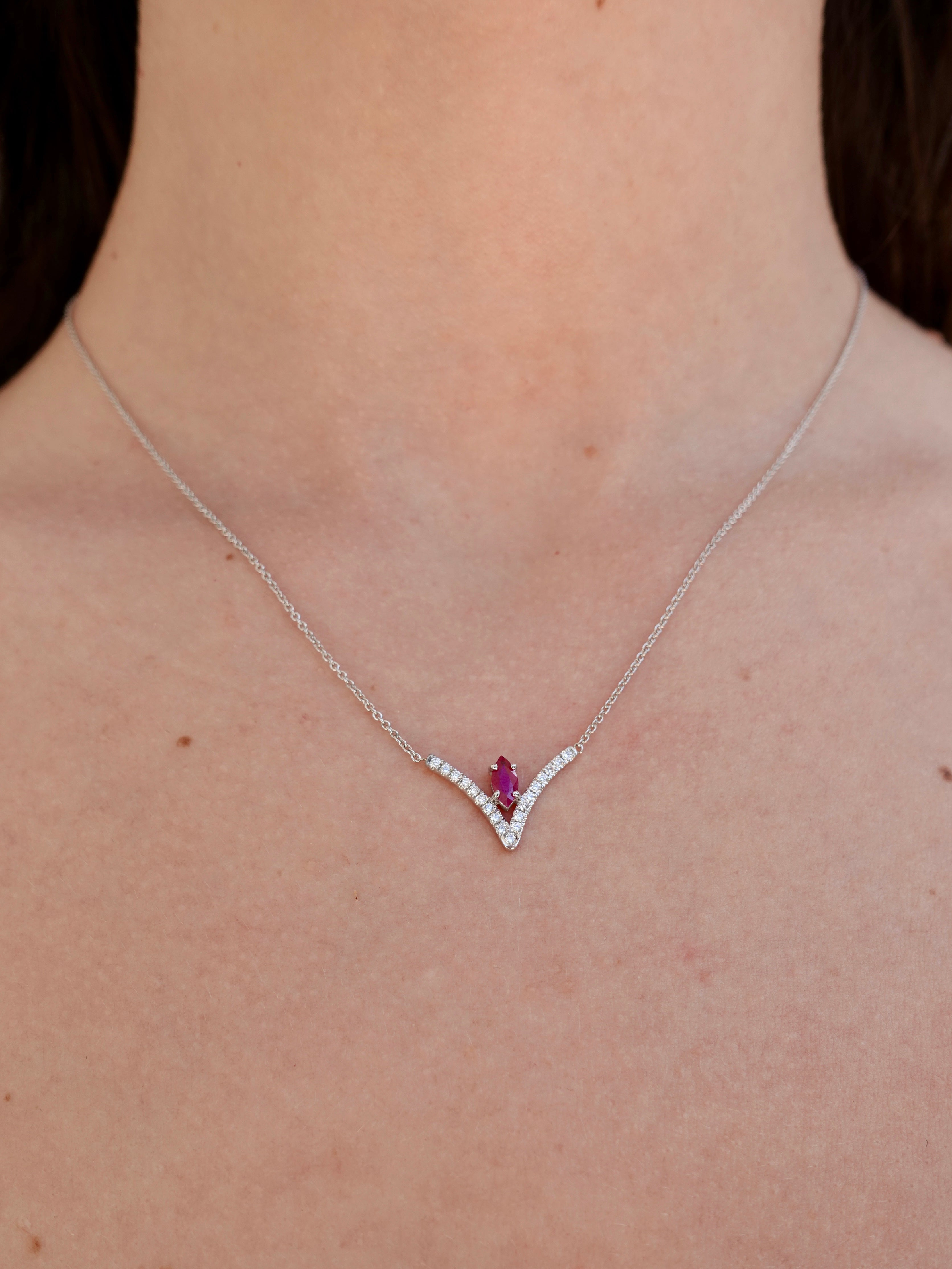 Necklace with a ruby gemstone worn by a person