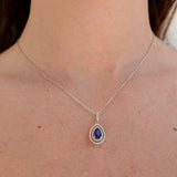 Necklace with a blue sapphire pendant worn by a person
