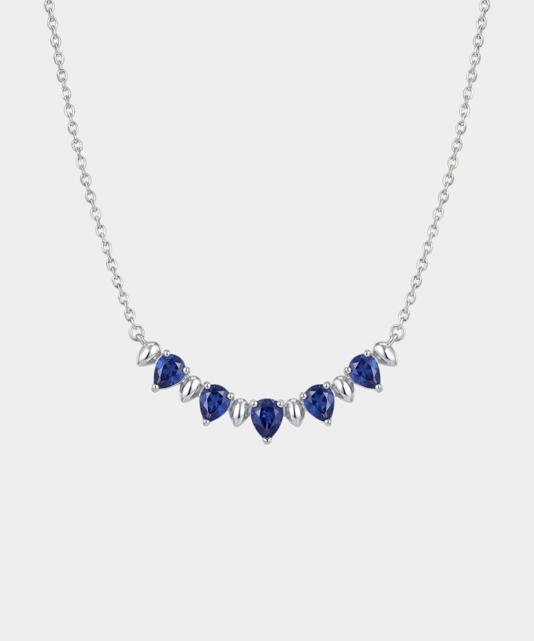 Necklace with blue teardrop-shaped sapphire gemstones on a white background