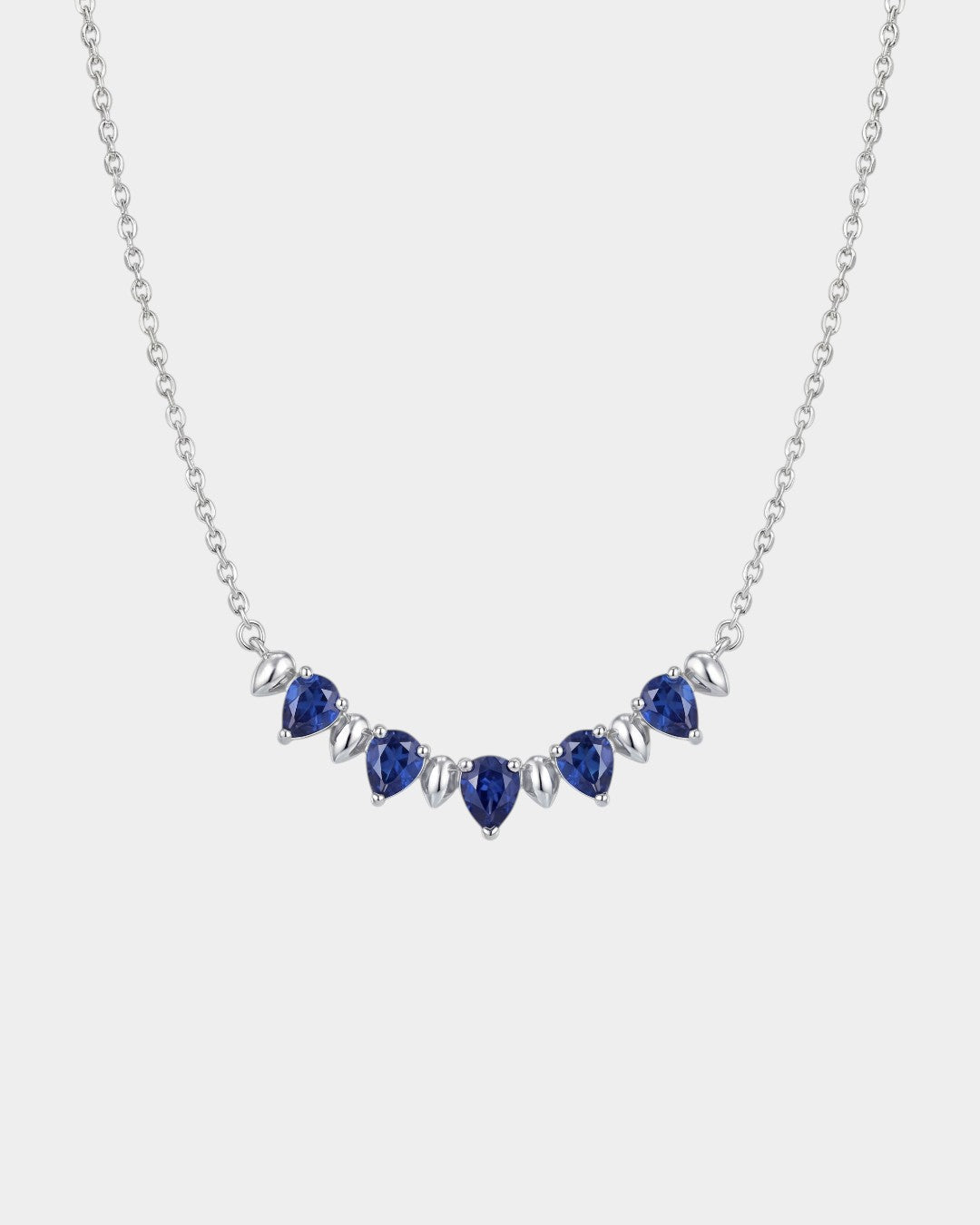 Necklace with blue teardrop-shaped sapphire gemstones on a white background