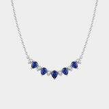 Necklace with blue teardrop-shaped sapphire gemstones on a white background