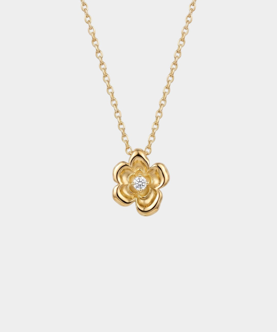 Gold flower-shaped necklace with a diamond on a white background