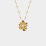 Gold flower-shaped necklace with a diamond on a white background