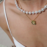 Pearl necklace and a flower pendant worn by a person