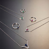 Silver jewelry set with rings and necklaces on a gradient background