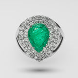 Ring with a green gemstone and diamond-studded halo on a light gray background