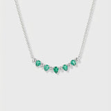 Necklace with pear-cut emeralds and white gold on a white background
